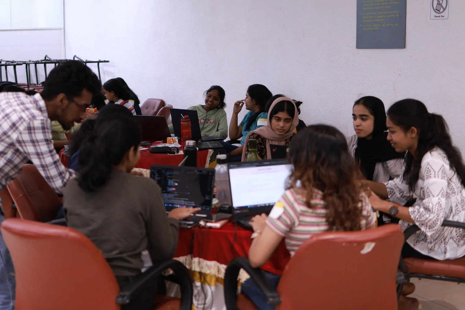 Students building together around laptops at Tink-Her-Hack